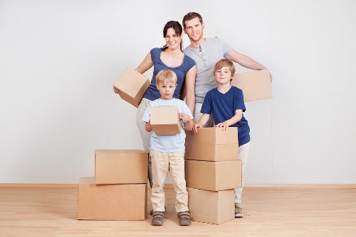 Mover carrying packed boxes during a house relocation