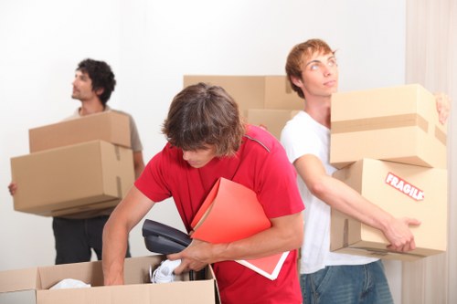 Professional movers handling stair access during a flat move in Colliers Wood
